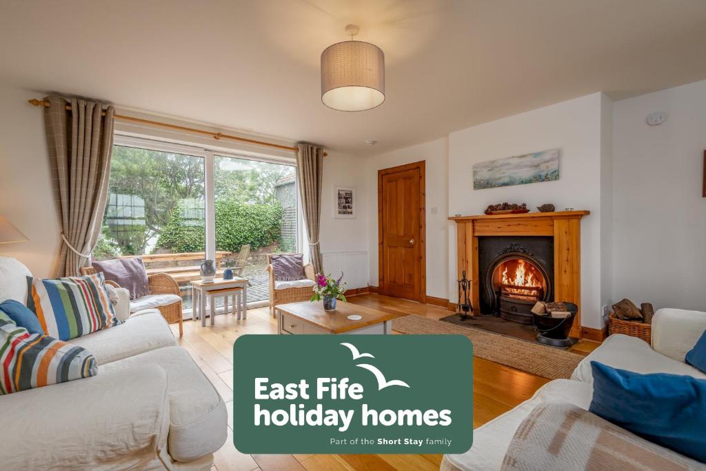 an image of a living room with a fireplace at Stable Cottage - Elie in Elie