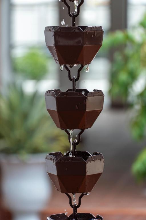 A close-up of a tiered chocolate fountain set among greenery.