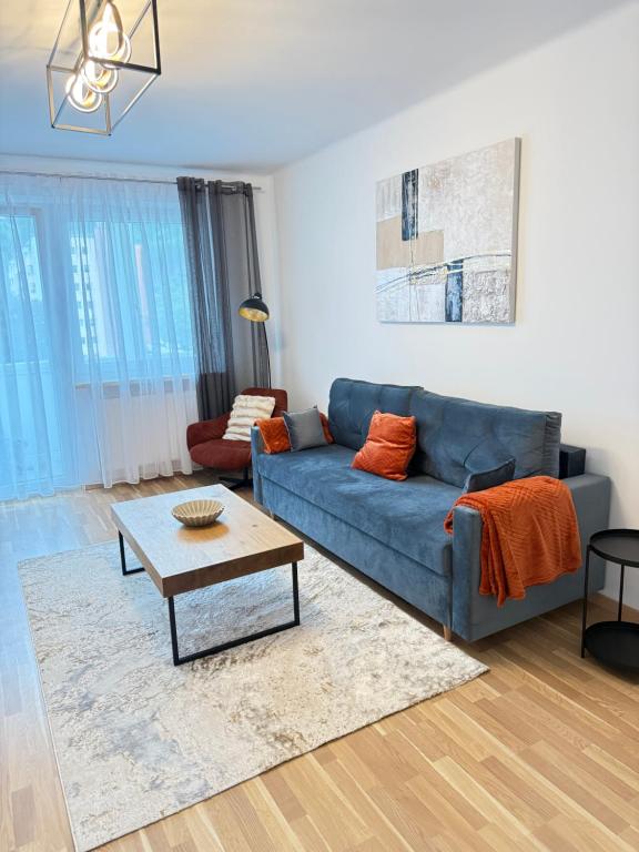 a living room with a blue couch and a table at TSD Living in Kapfenberg