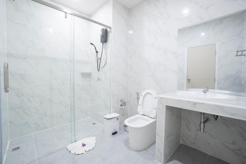 A bright tiled bathroom with a walk-in shower, toilet and vanity.