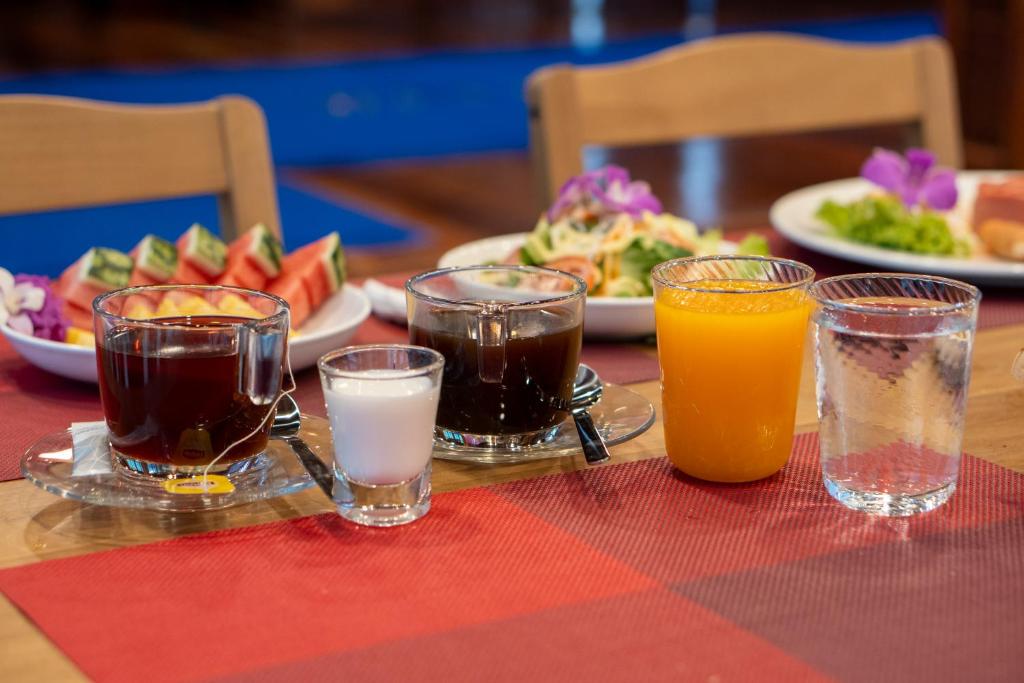 A breakfast table set with coffee, juice, fruit, salad, and water.