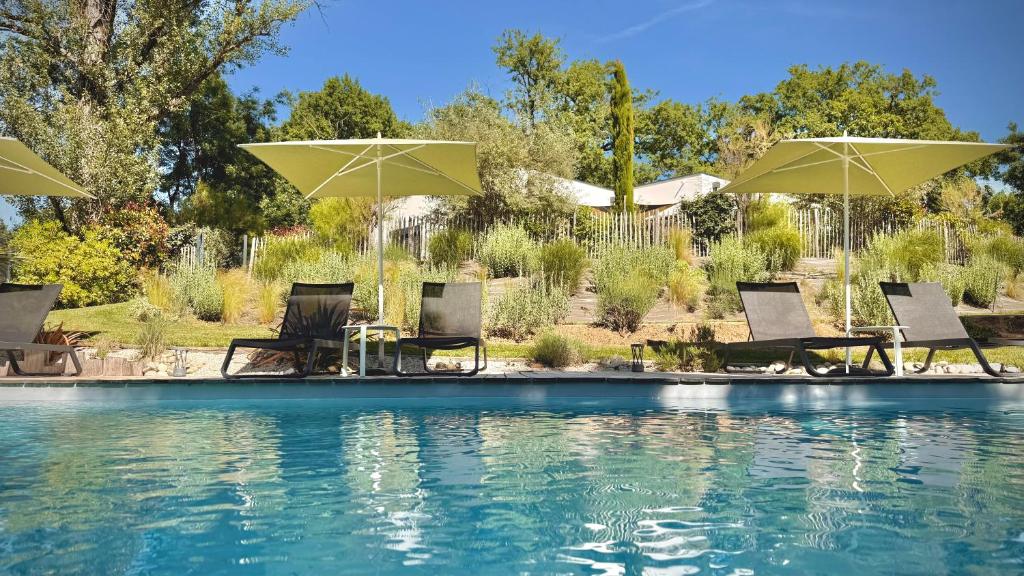a group of chairs and umbrellas next to a swimming pool at Chambres avec Jacuzzi privatif - Kassiopée Bed & Spa in Albi