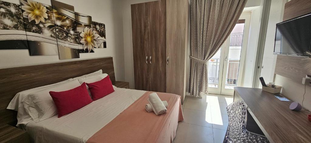 a bedroom with a bed with red pillows and a television at Mary Vi Rooms in Peschici
