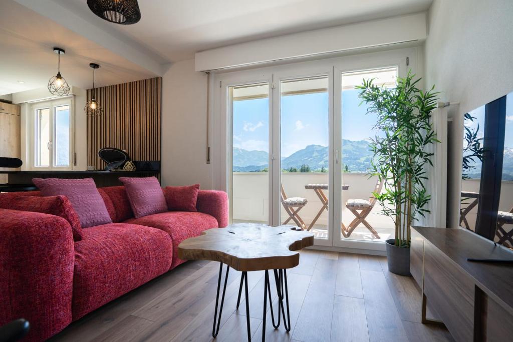 a living room with a red couch and a table at La vue Appartement Gruyère in Bulle