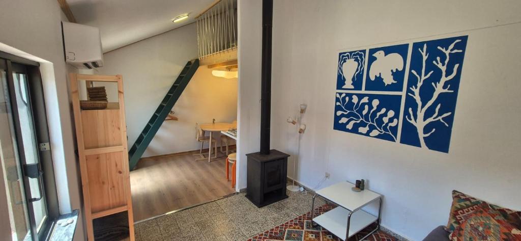 a living room with a fireplace and a staircase at Studio Juncalinho - Stylish Portuguese Studio in São Teotónio