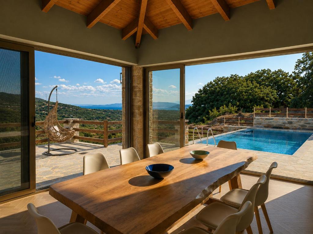 a dining room with a wooden table and a pool at Bellevia Stone Pool Villa in Kouvéllai
