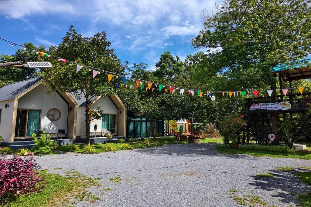 a house with a string of flags hanging from it at Pool Villa Baan Suan Phrom Khiri in Nakhon Si Thammarat