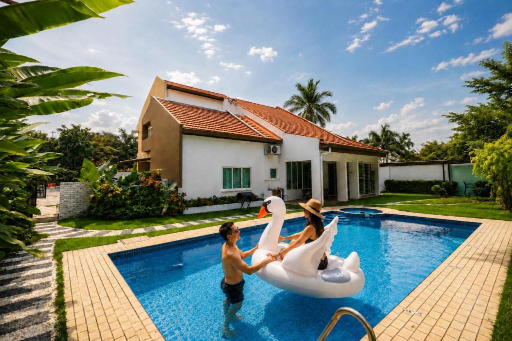 a group of children playing with swans in a swimming pool at Bungalow Perkasa in Kuala Lumpur