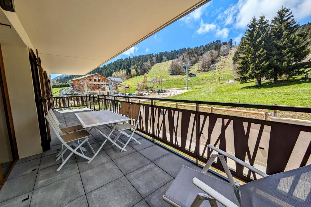 a balcony with a table and chairs and a view at L'écrin des neiges - Sauna in La Féclaz