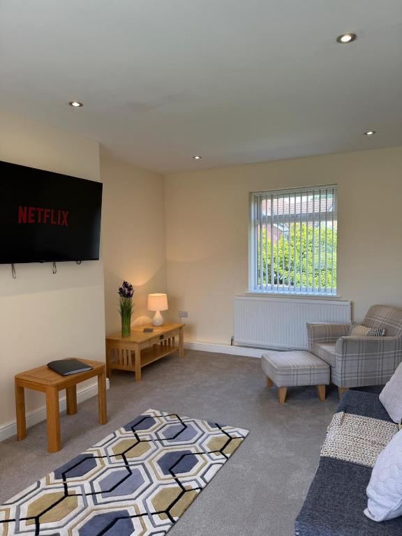 a living room with a couch and a tv at Tudor House in Osgodby
