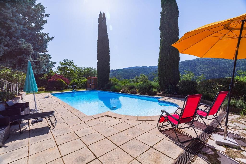 a pair of chairs and an umbrella next to a swimming pool at Les Issignols - Chambre d'hotes in Colombier-le-Vieux