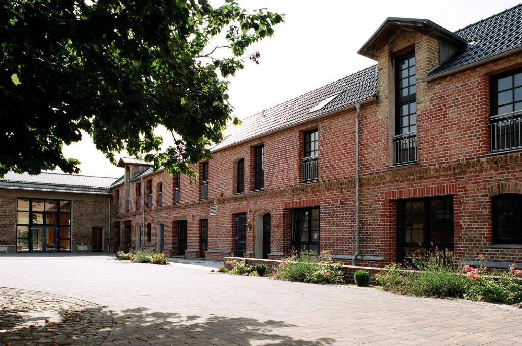 ein Backsteingebäude mit einem Innenhof davor in der Unterkunft Hof Märkische Heide in Brandenburg an der Havel