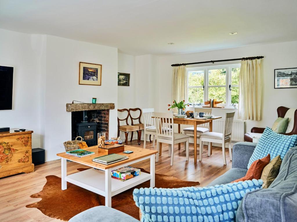 a living room with a couch and a table at Finest Retreats - Coachmans Cottage in Lapford