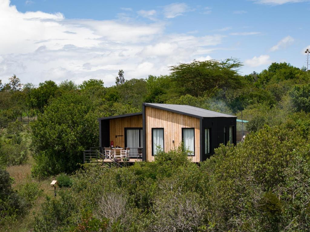 a small house in the middle of a field at Pods at Aloe Valley, Ngobit Laikipia in Gatunga