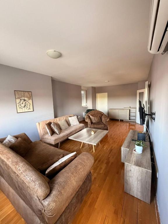 a living room with two couches and a table at Apartman Enigma II in Ruma
