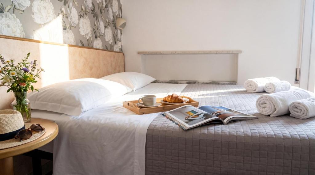 a white bed with a tray of food on it at Brasilia Sweet Home in Cesenatico