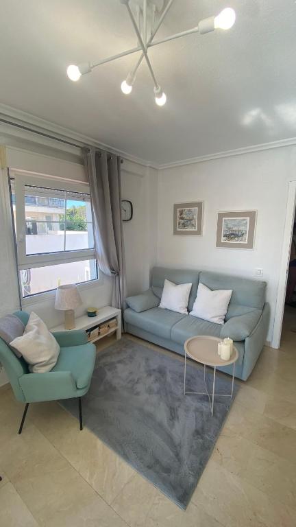 a living room with a blue couch and a table at Sunylife in Albir