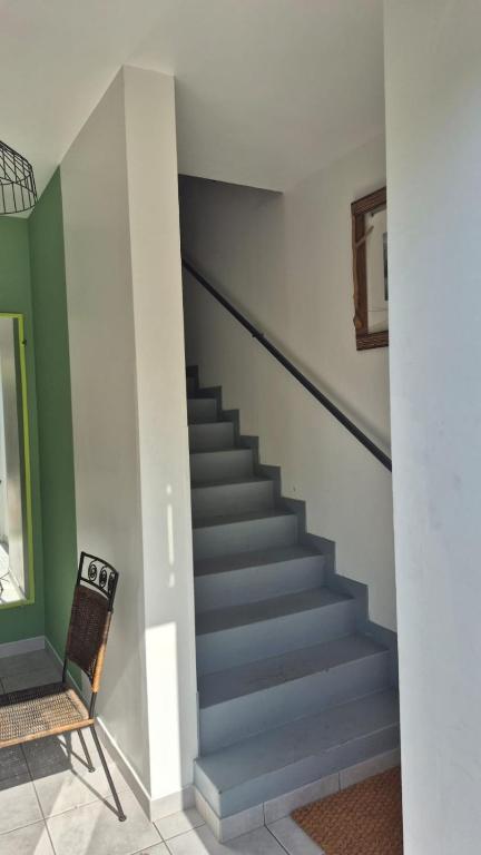 a staircase in a room with a chair and a stair case at Biloba in Saint-Paul-lès-Dax
