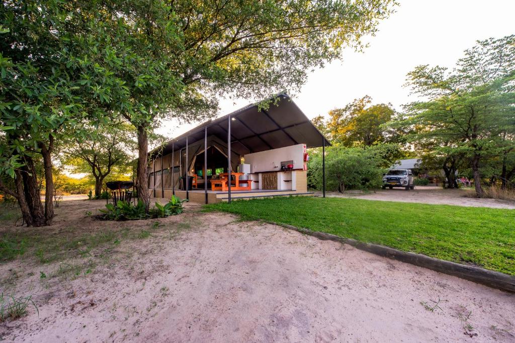 a house with a black roof in a park at Hakusembe River Camping2Go in Kansukwa