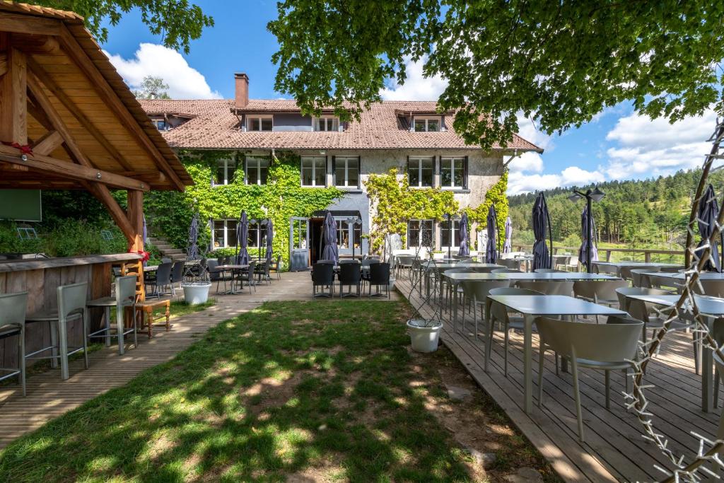 a patio with tables and chairs in front of a building at Logis Hôtel la Vigotte in Girmont-Val-dʼAjol