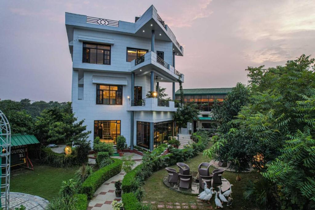 a large blue house with chairs in the yard at River View Resort in Haridwār