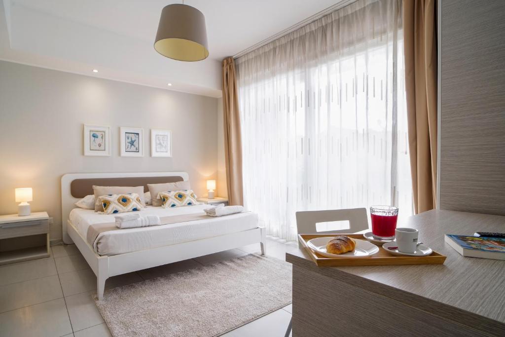 a bedroom with a bed and a table with a tray of food at Pietra Bianca Rooms in Pachino