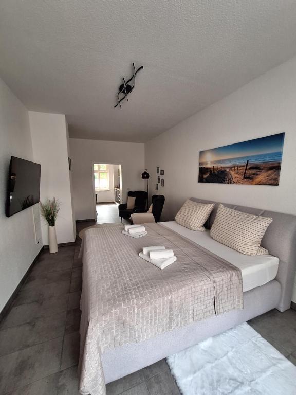 a bedroom with a large bed and a living room at Ferienwohnung III in Eisenhüttenstadt