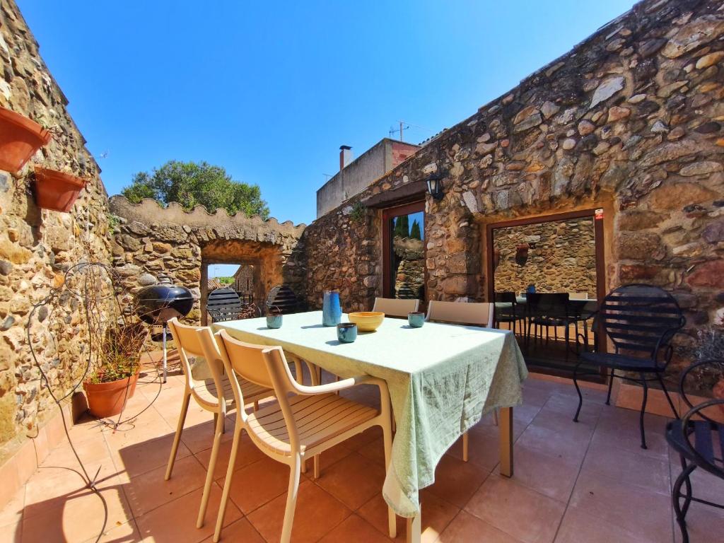 a stone building with a table and chairs on a patio at Casa historica en Corçà, Baix Empordà in Corçà
