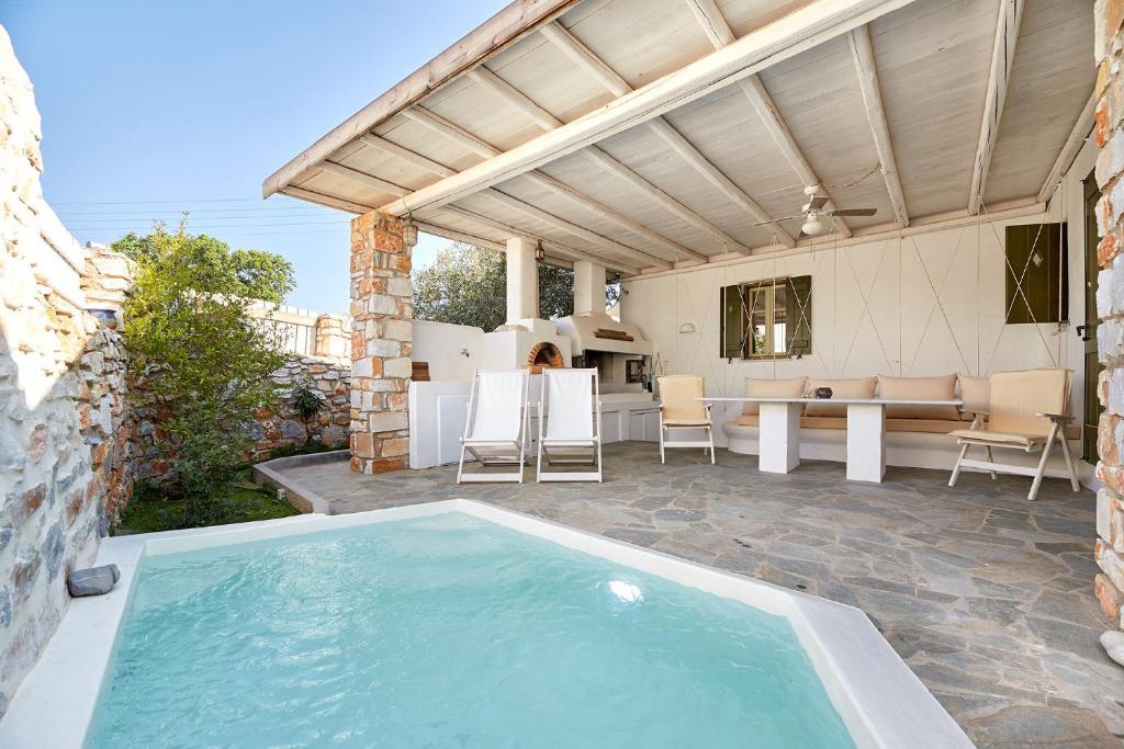 an outdoor patio with a swimming pool and a house at Villa Joy in Aliki