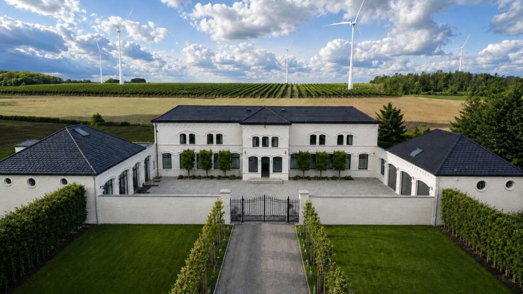 Luftaufnahme eines weißen Hauses mit Auffahrt in der Unterkunft Hôtel Éole Resort - Mons - Shape - Pairi Daiza in Warchaix