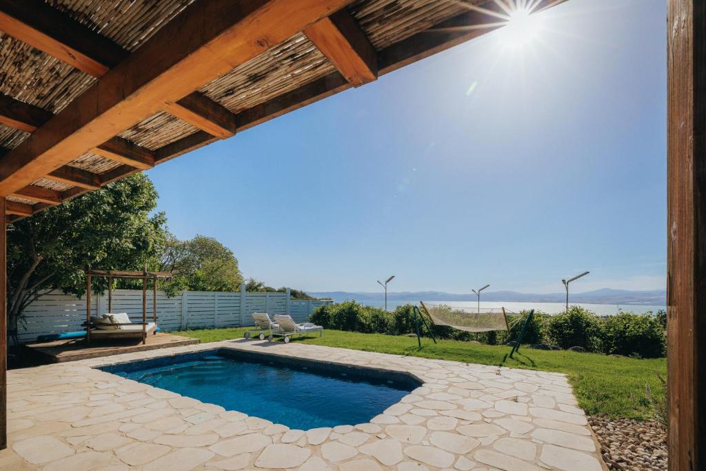 a swimming pool in a yard with a patio at The White Chalet Boutique in Moshav Ramot
