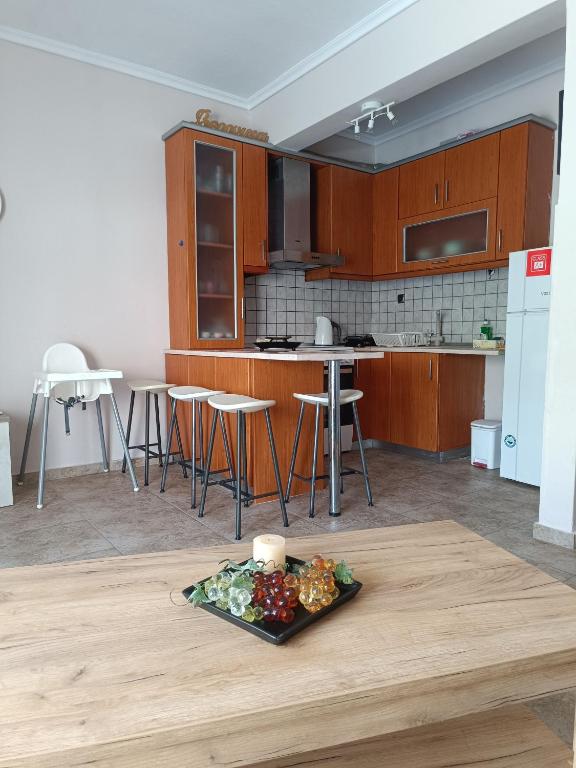 a kitchen with wooden cabinets and a plate of food on a table at Summer apartment in Nea Peramos