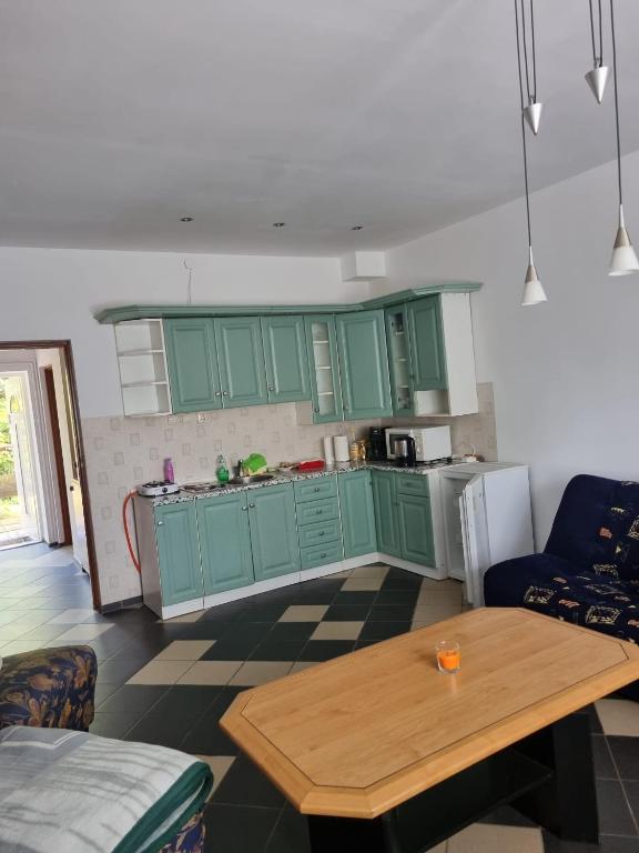 a kitchen with green cabinets and a wooden table at Kłączyn in Kłaczno