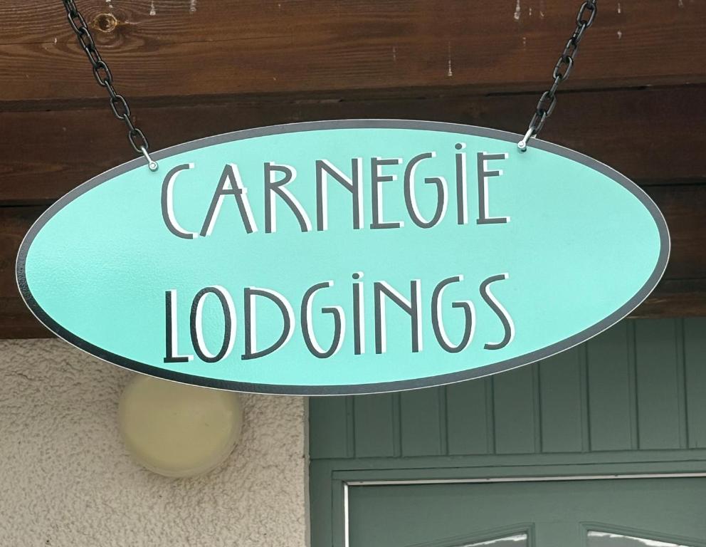 a sign that reads carriage lodges hanging in front of a door at Carnegie Lodgings, Tain in Tain