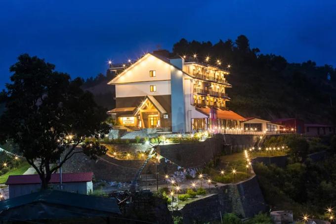 a large building with lights in front of it at night at DANFÉ Lodge Halesi in Lamidanda