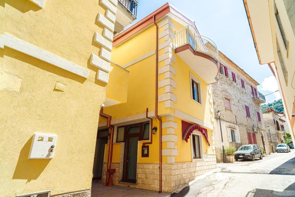 a yellow building on the side of a street at Santa Maria Rooms in Santa Maria di Castellabate