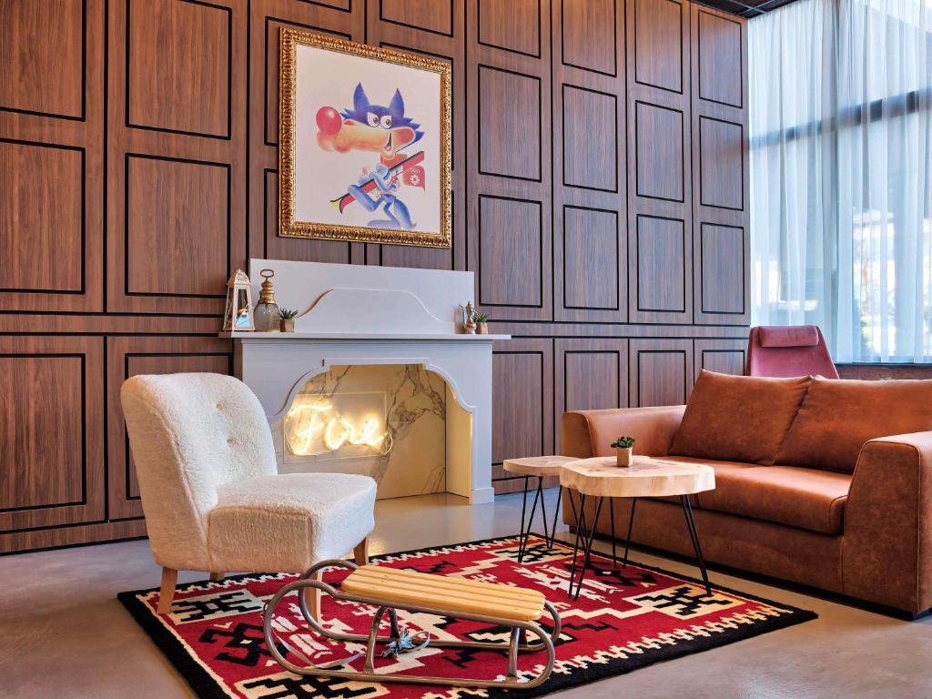 a living room with a couch and a chair at ibis Styles Sarajevo in Sarajevo