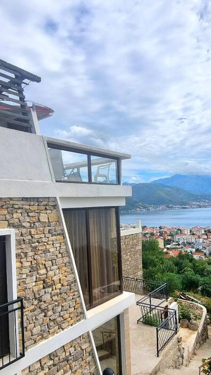 a house with a balcony with a view of the water at Kotor Bay View Apartments in Bijela
