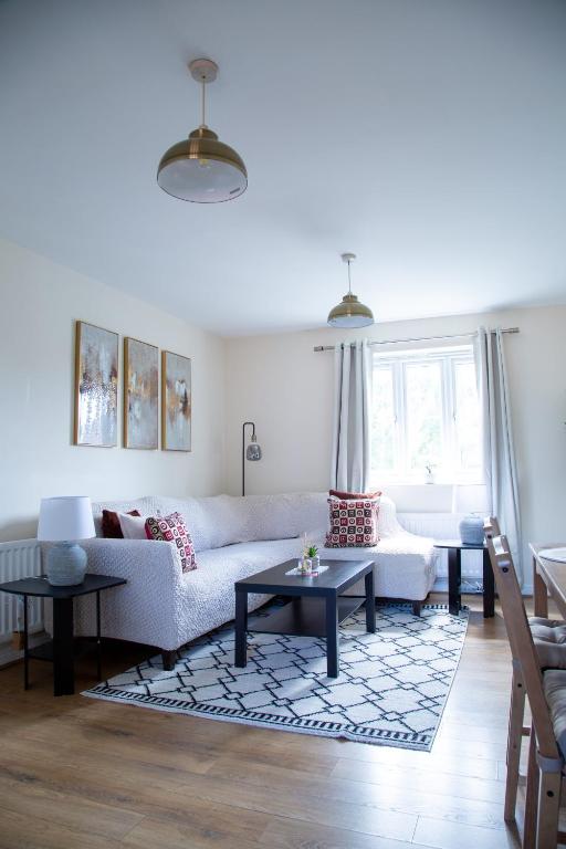 a living room with a white couch and tables at Luxury 2 Bedroom serviced accommodation in Solihull