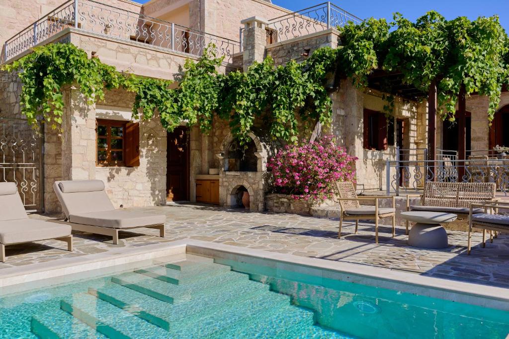 a house with a swimming pool in front of a house at Villa Iremia in Nísi