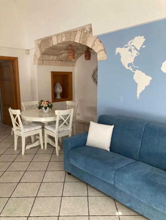 a living room with a blue couch and a table at Casa Annacarla in Noci