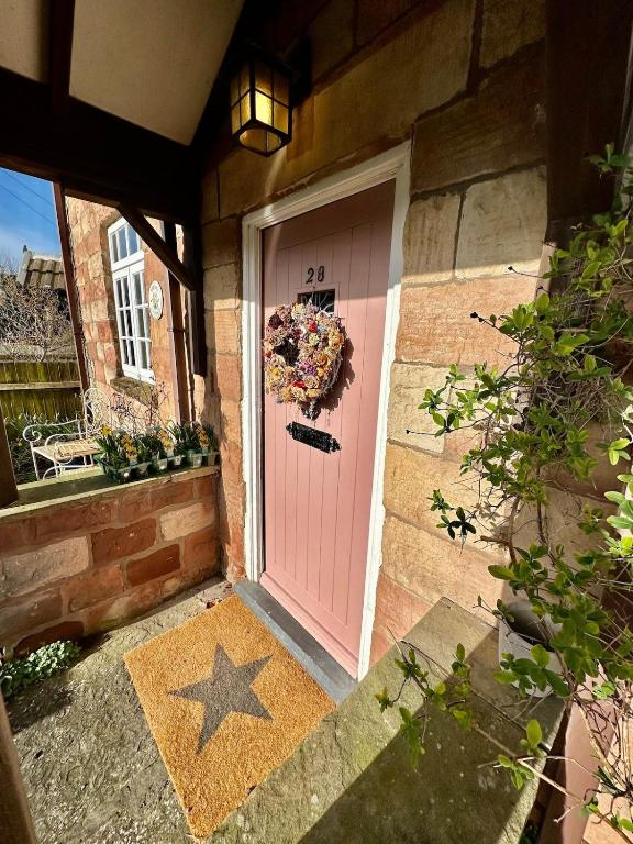 a pink door with a wreath on it at Spring Cottage in Hoylake