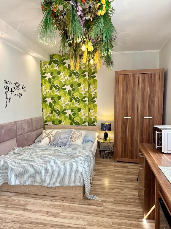 a bedroom with a bed and a wall with flowers at Pokoje Gościnne in Kołobrzeg