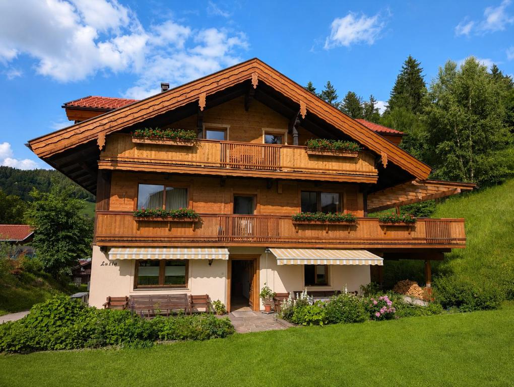 a wooden house with a balcony on a hill at Haus Luzia in Reith im Alpbachtal