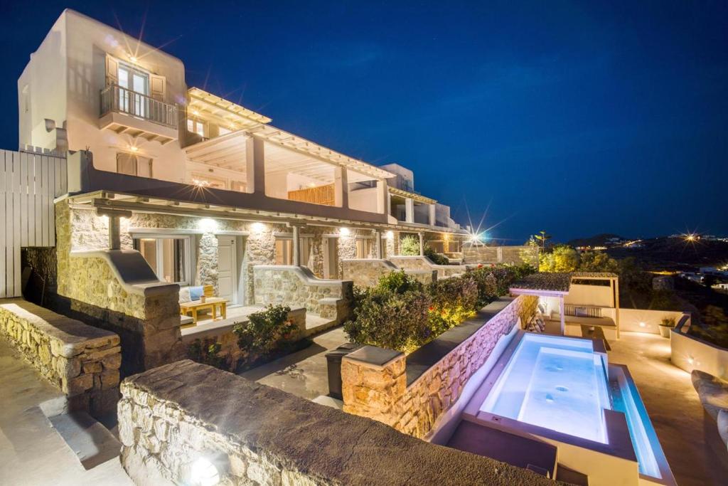 a house with a swimming pool at night at Overview Mykonos Apartments in Mikonos