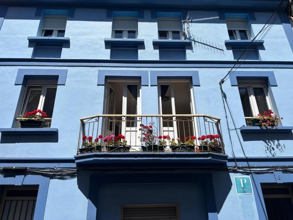 a blue building with flower boxes on the windows at Pension Alver - El Refugio del Artista in Cudillero
