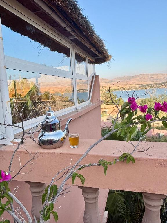 a tea pot sitting on a ledge next to a window at LOUIZA HOUSE, vue imprenable entre lac et désert in Lalla Takerkoust