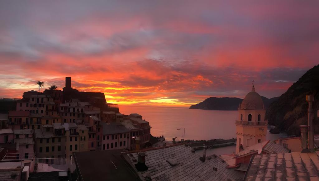 a sunset over a city with a building and the ocean at Casa D'ambra in Vernazza