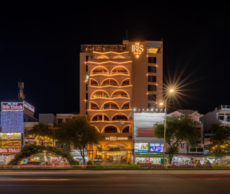 a tall building with lights on it at night at The IRIS SIGNATURE HOTEL AND SPA in Can Tho