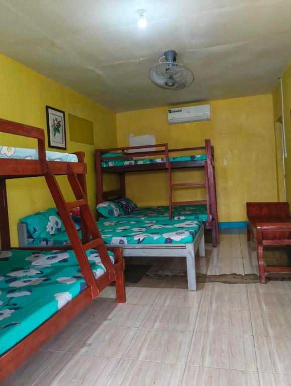 a room with two bunk beds and a chair at Vilma Transient House in Bolinao